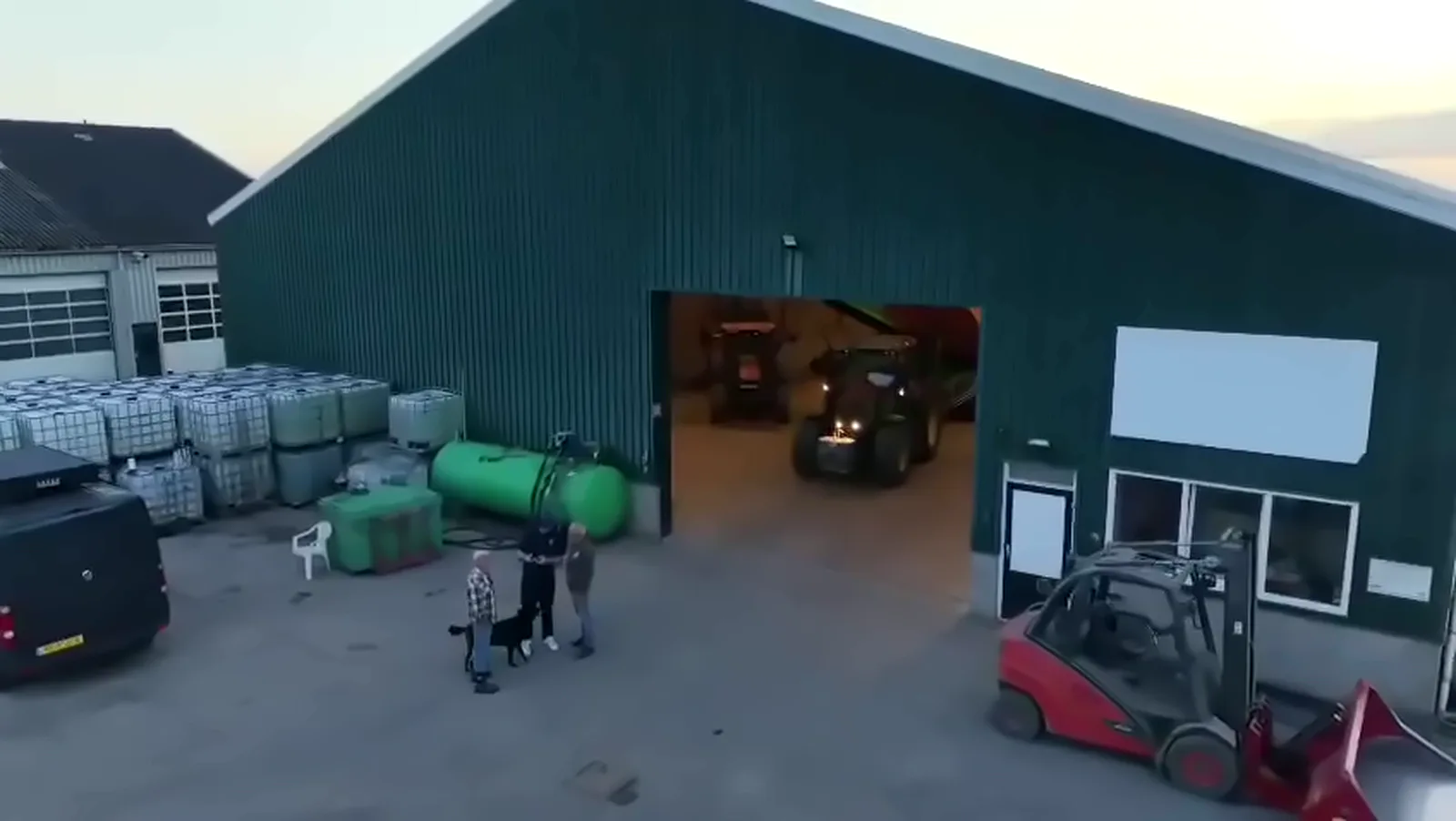 Luchtfoto van de bedrijfsschuur met trekker en heftruck